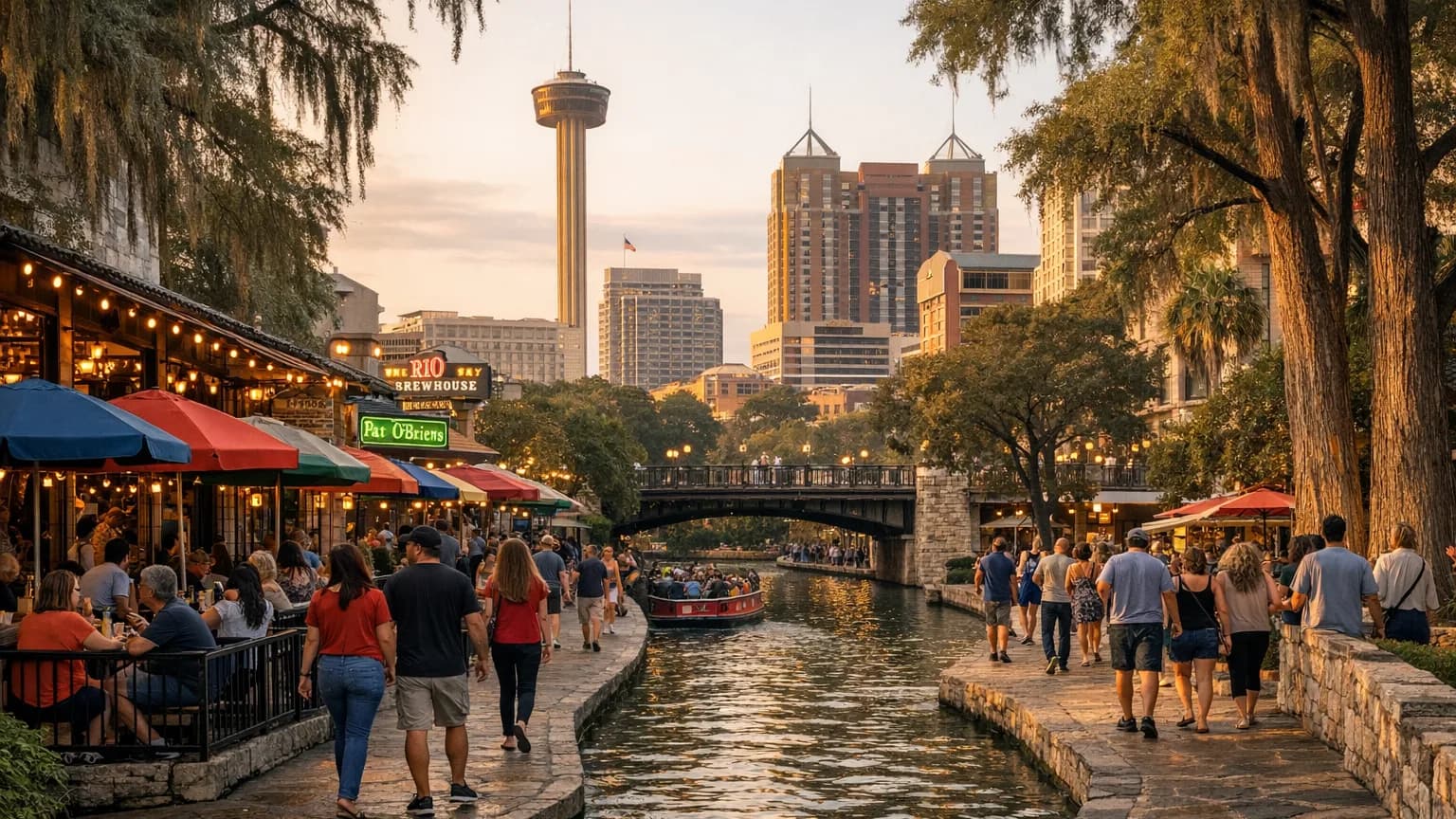 The San Antonio River Walk downtown at golden hour, with riverside cafes, a river barge, and the Tower of the Americas behind